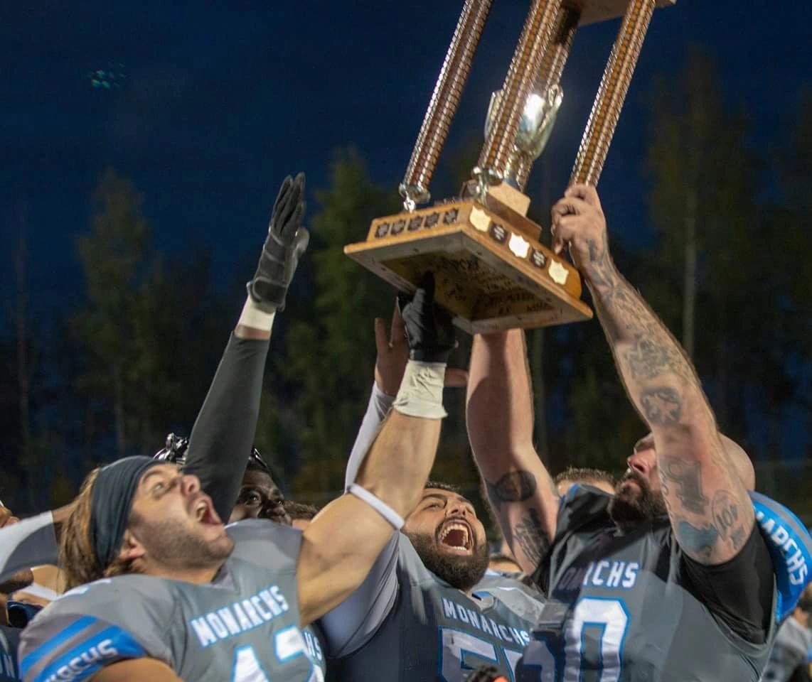 Monarchs players hoisting the national championship trophy
