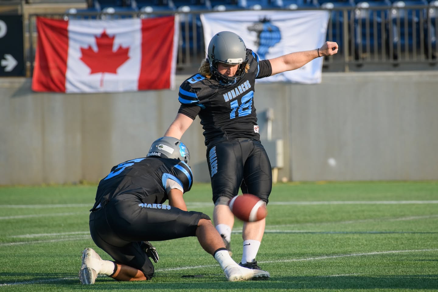 Monarchs kicker with Canadian flag at SMS Equipment Stadium