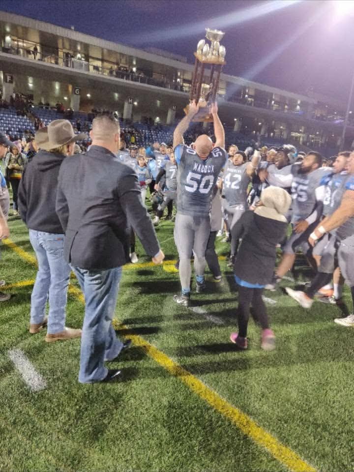 Monarchs #50 Maddox hoisting the championship trophy at SMS Stadium