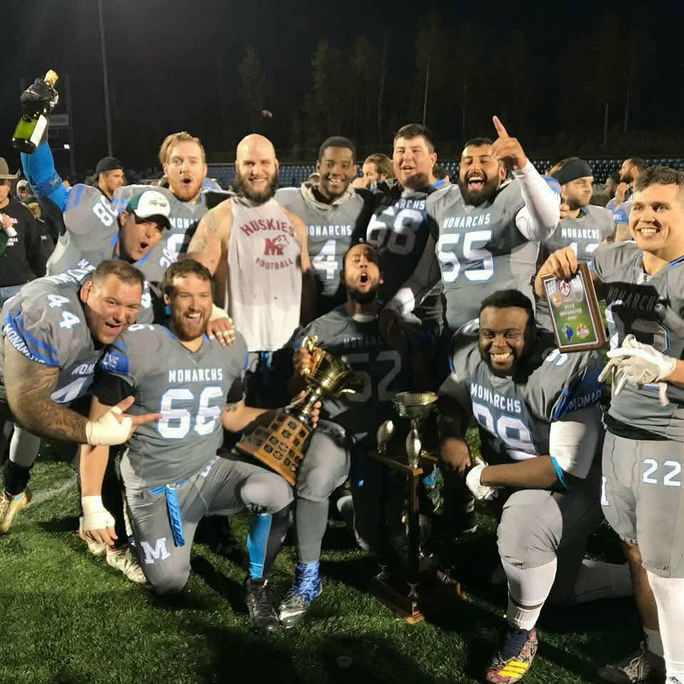 Monarchs players celebrating with championship trophy and plaque